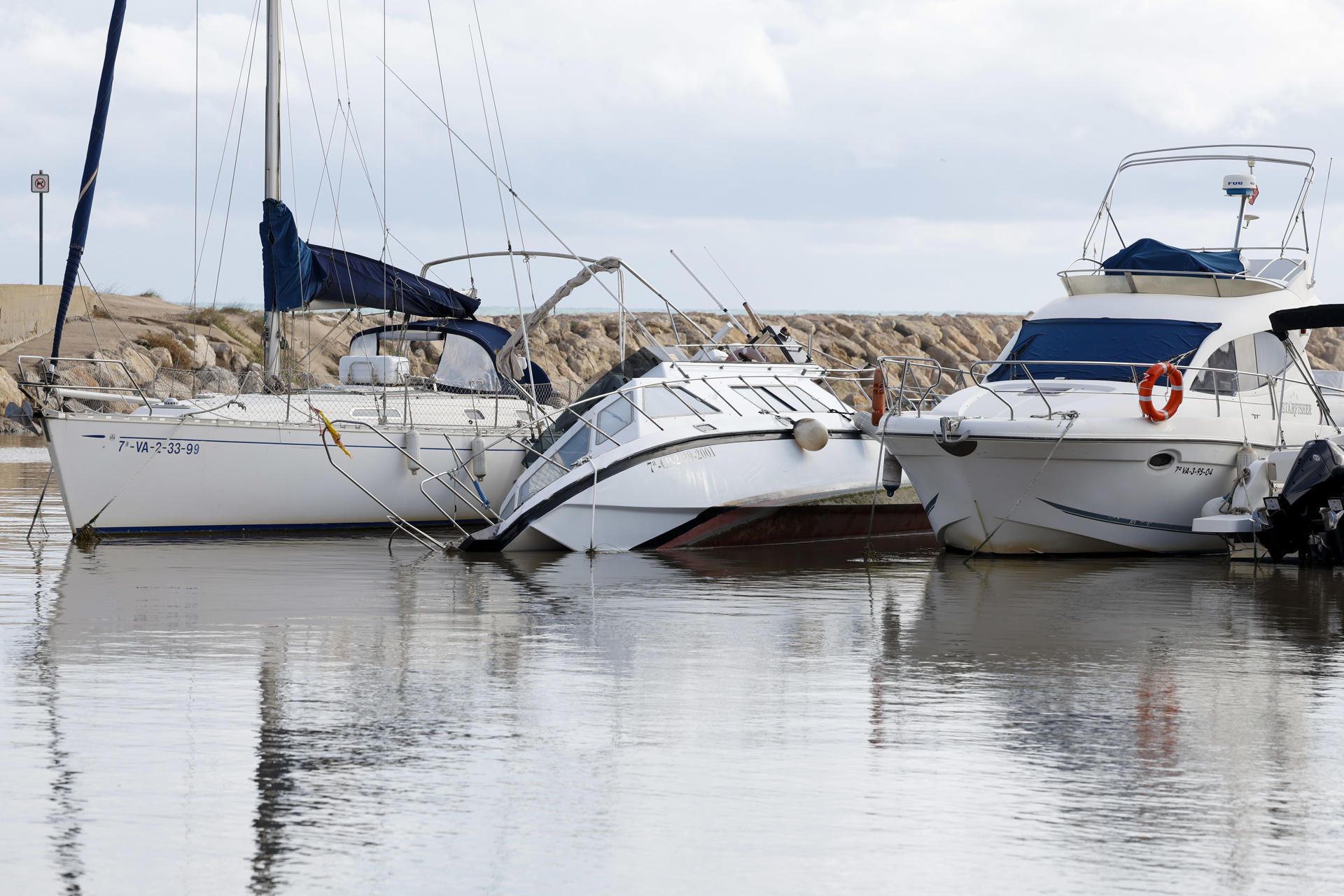 Varios barcos permanecen hundidos a causa del temporal de lluvia, este martes en Perelló (Sueca). EFE/ Ana Escobar
