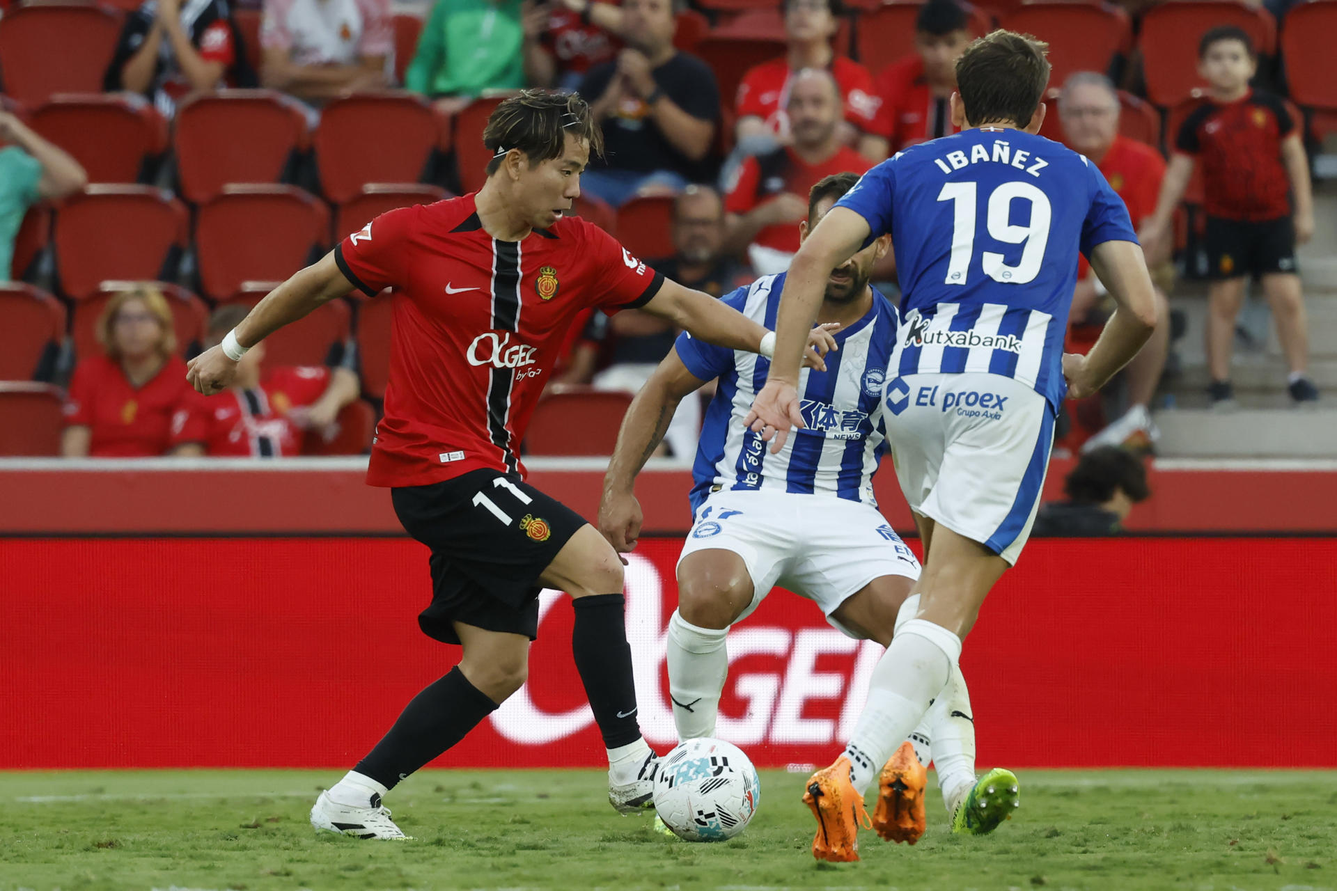 El delantero del Mallorca, Takuma Asano (i), con el balón ante los jugadores del Alavés durante el encuentro correspondiente a la jornada 7 de Laliga EA Sports que disputan Mallorca y Alavés en el estadio de Son Moix, en la capital balear. EFE/CATI CLADERA.
