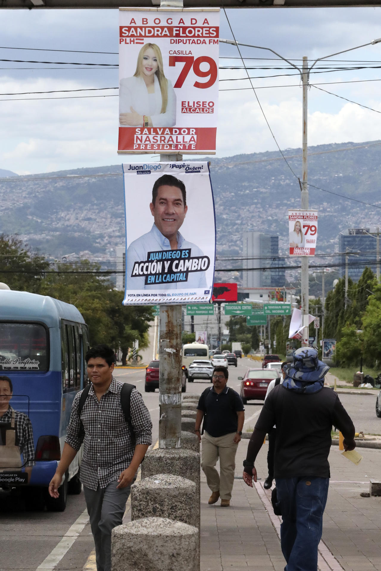 Una persona camina junto a carteles alusivos a la campaña electoral este lunes, en Tegucigalpa (Honduras). EFE/ STR