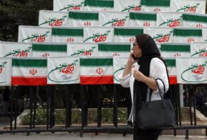 TEHRAN, 27/09/2025.- Una mujer pasea por delante de decenas de banderas iraníes en el centro de Teheran. (Francia, Alemania, Reino Unido, Teherán) EFE/EPA/ABEDIN TAHERKENAREH