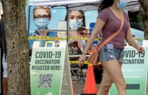 Personas caminan frente a un centro de vacunación contra la Covid-19. EFE/EPA/CRISTOBAL HERRERA-ULASHKEVICH