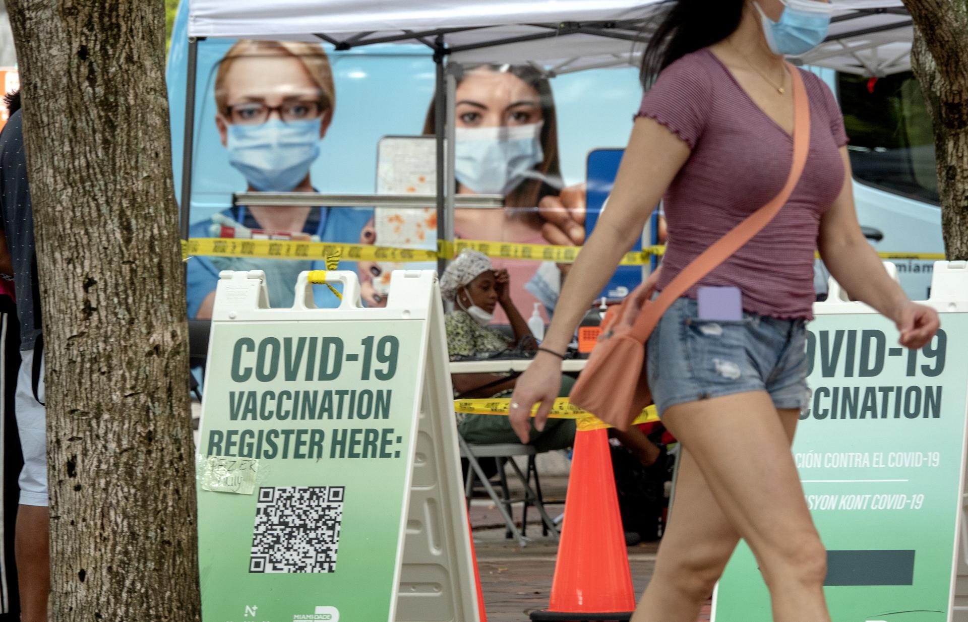 Personas caminan frente a un centro de vacunación contra la Covid-19. EFE/EPA/CRISTOBAL HERRERA-ULASHKEVICH