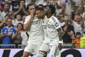 El delantero francés del Real Madrid Kylian Mbappé (c) celebra con Álvaro Carreras (izda) y Vinicius el segundo gol conseguido durante el partido de la jornada 5 de LaLiga EA Sports, que disputan el Real Madrid y el RCD Espanyol, en el estadio Santiago Bernabéu de la capital española. EFE/Fernando Villar