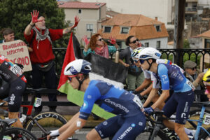 Los ciclista del equipo Israel Premier Tech pasan ante las protestas propalestina durante la etapa 16 de la Vuelta Ciclista a España. EFE/ Lavandeira Jr