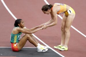 La atleta española Marta Perez (R) ayuda a levantarse a la etíope Freweyni Hailu tras la prueba de los 1500 metros en los Mundiales de Tokio 2025. EFE/EPA/KIYOSHI OTA
