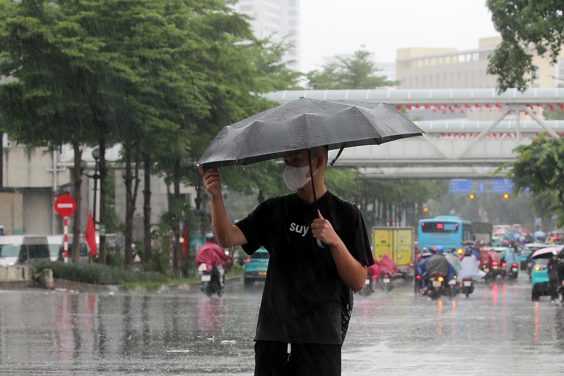 Una persona bajo un paragüas en Hanói por la llegada del tifón Bualoi.
EFE/EPA/LUONG THAI LINH