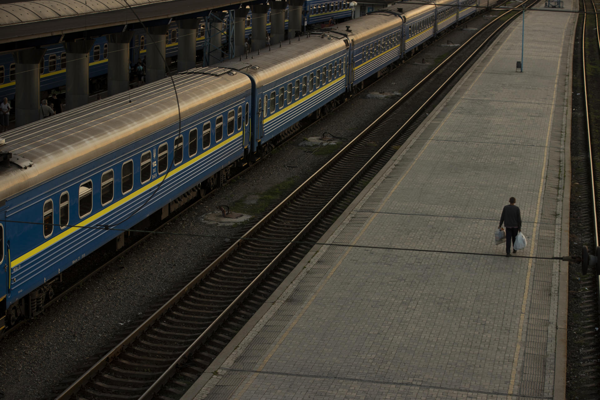 Un hombre camina en un andén de trenes de la "Ukrzaliznytsia", la empresa estatal de ferrocarriles de Ucrania. EFE/Orlando Barría