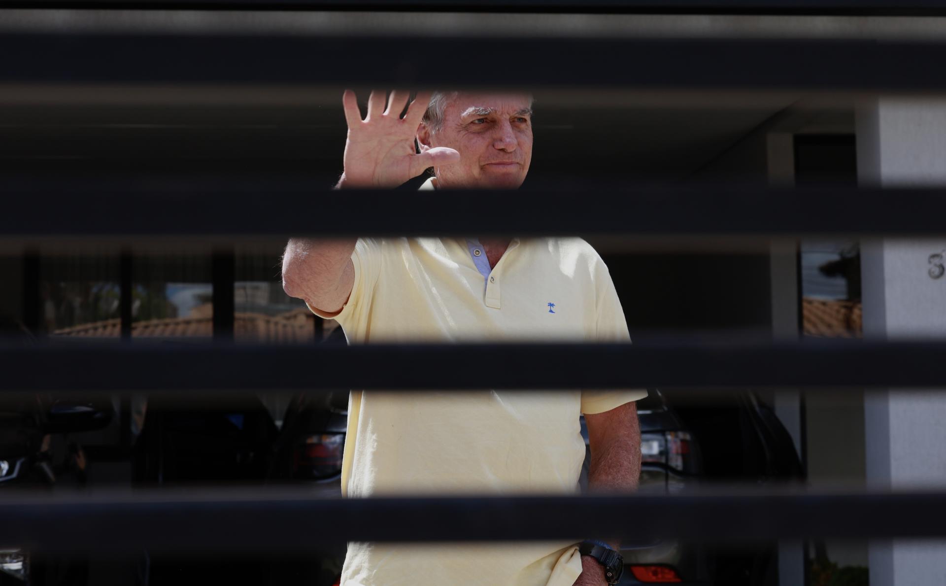 El expresidente de Brasil Jair Bolsonaro al saludar el pasado 3 de septiembre desde el interior de su residencia, en Brasilia (Brasil). EFE/Sebastiao Moreira