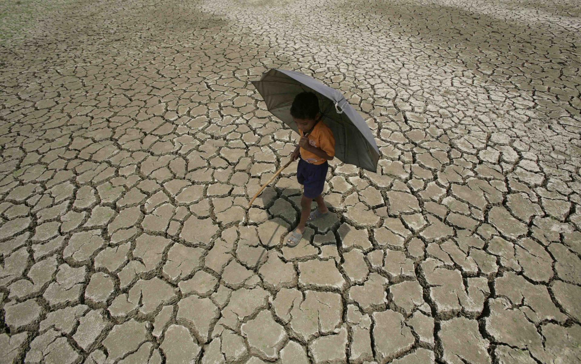 En la imagen de archivo, un niño indio camina por un terreno agrietado, en el pasado una charca, debido a la fuerte sequía, en Bhubaneswar, Orissa, la India. EFE