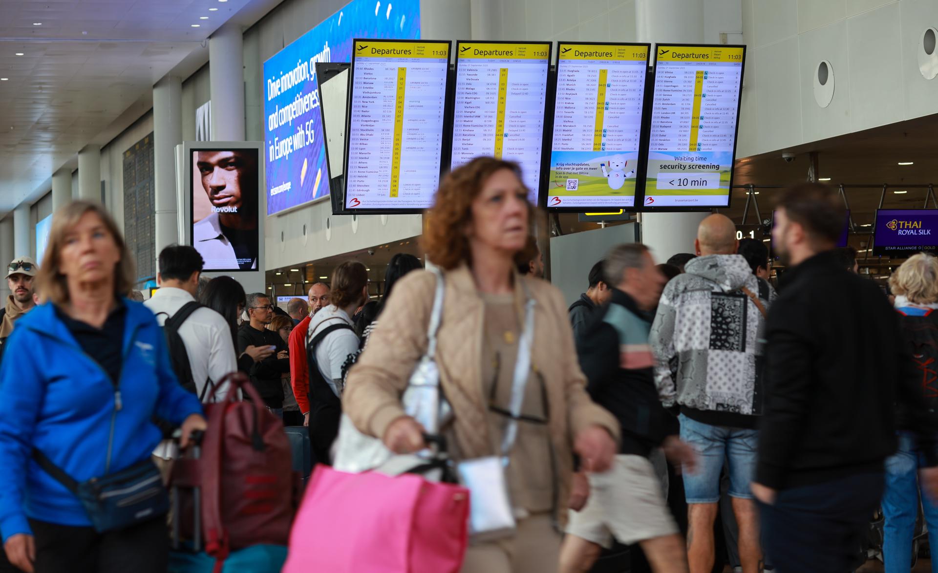Pasajeros caminan este domingo en el aeropuerto de Bruselas, donde decenas de vuelos estaban cancelados hoy debido a un ciberataque el viernes por la noche que afecto al sistema de facturación y embarque. EFE/EPA/OLIVIER HOSLET