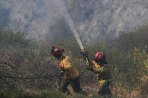 Fotografía de archivo, tomada en septiembre de 2024, de un par de bomberos al atender un incendio forestal, en inmediaciones de Quito (Ecuador). EFE/José Jácome
