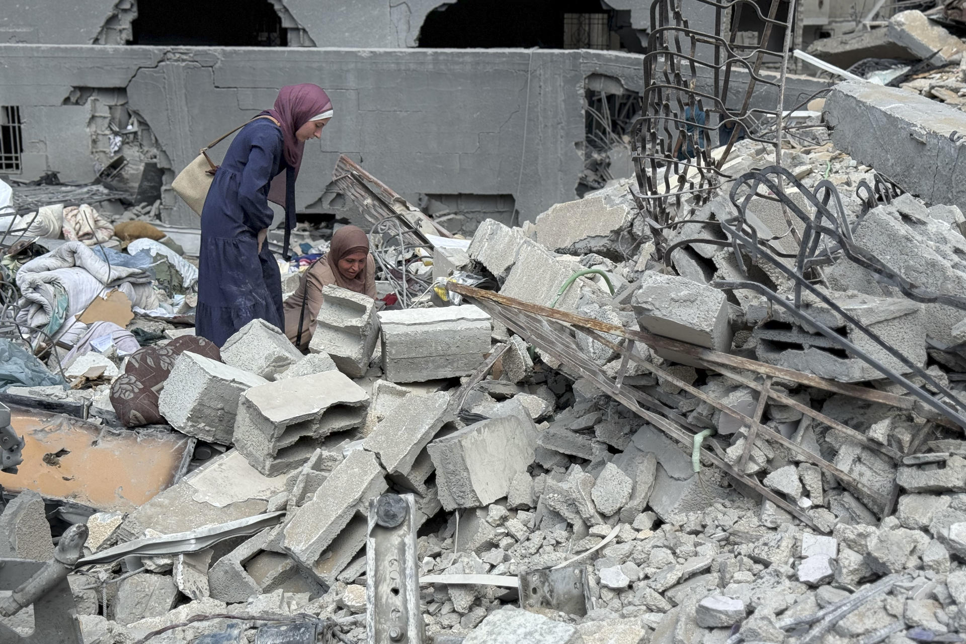 CIUDAD DE GAZA, 15/09/2025.- Unos ciudadanos gazatíes intentan salvar este lunes algunas de sus pertenencias entre los escombros de la torre Al Jundi, en la ciudad de Gaza, que fue derribada ayer, domingo, por el ejército de Israel. EFE/ Ahmad Awad