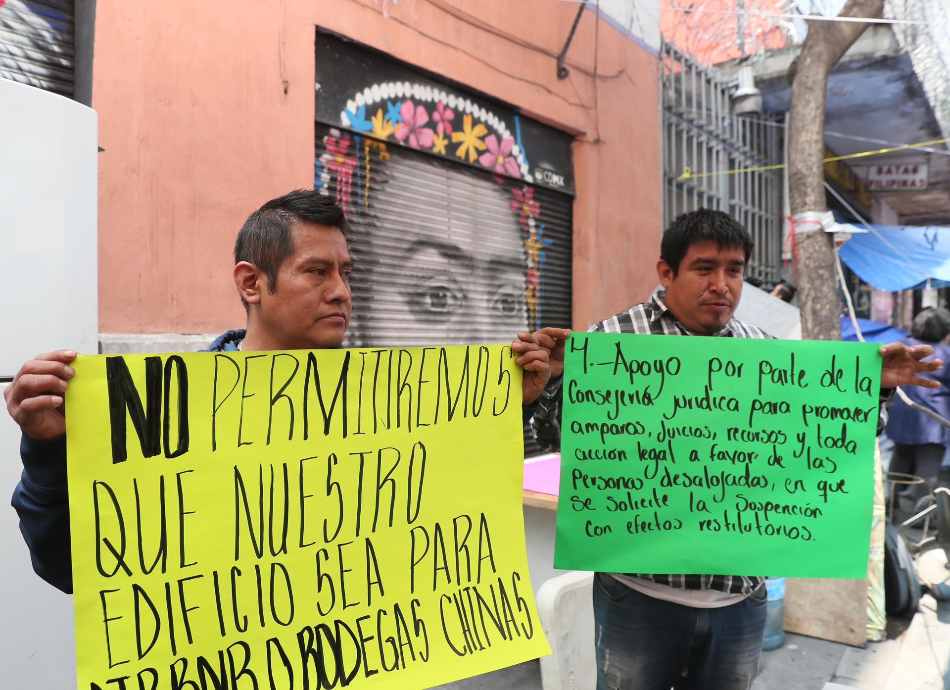 Gerardo Pedro Antonio (i) y Anselmo Pérez (d) protestan este jueves después de un desalojo en el Centro Histórico de la Ciudad de México (México). EFE/Mario Guzmán