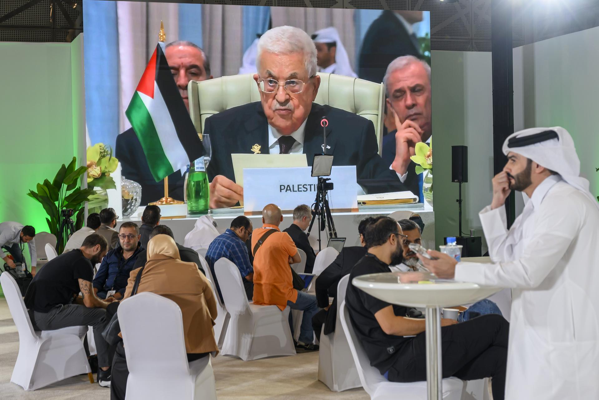 DOHA (Qatar), 15/09/2025.- Journalists watch a speech by Palestinian President Mahmoud Abbas on a screen at the media centre during the opening of the emergency Arab-Islamic summit to discuss the Israeli attack on Qatar in Doha, Qatar, 15 September 2025. (Catar) EFE/EPA/NOUSHAD THEKKAYIL
