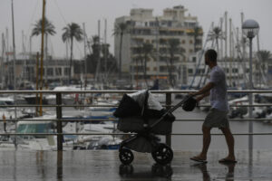 Un hombre junto al puerto de Palma de Mallorca, donde este martes ha llegado un temporal de lluvia y viento. EFE/Miquel A. Borrás
