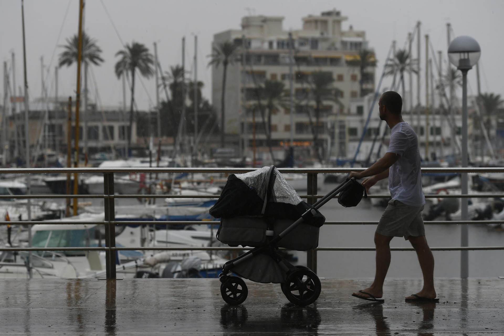 Un hombre junto al puerto de Palma de Mallorca, donde este martes ha llegado un temporal de lluvia y viento. EFE/Miquel A. Borrás