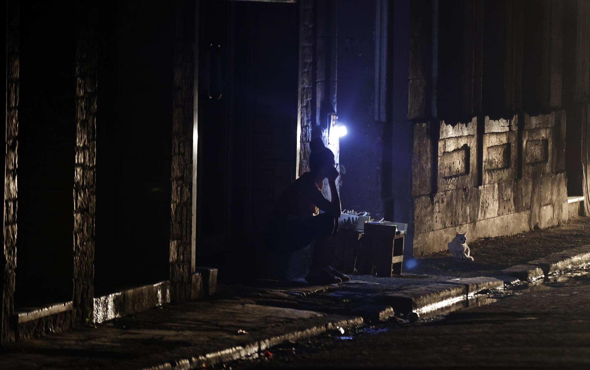 Una persona espera el regreso de la electricidad afuera de su casa el miércoles, en La Habana (Cuba). EFE/Ernesto Mastrascusa