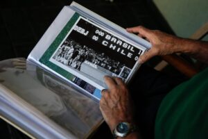 El exárbitro argentino Juan Carlos Lousteau muestra fotografías del 3 de septiembre de 1989 dirigió el partido de eliminatorias del Mundial de Italia'90 entre Chile y Brasil. EFE/Juan Ignacio Roncoroni