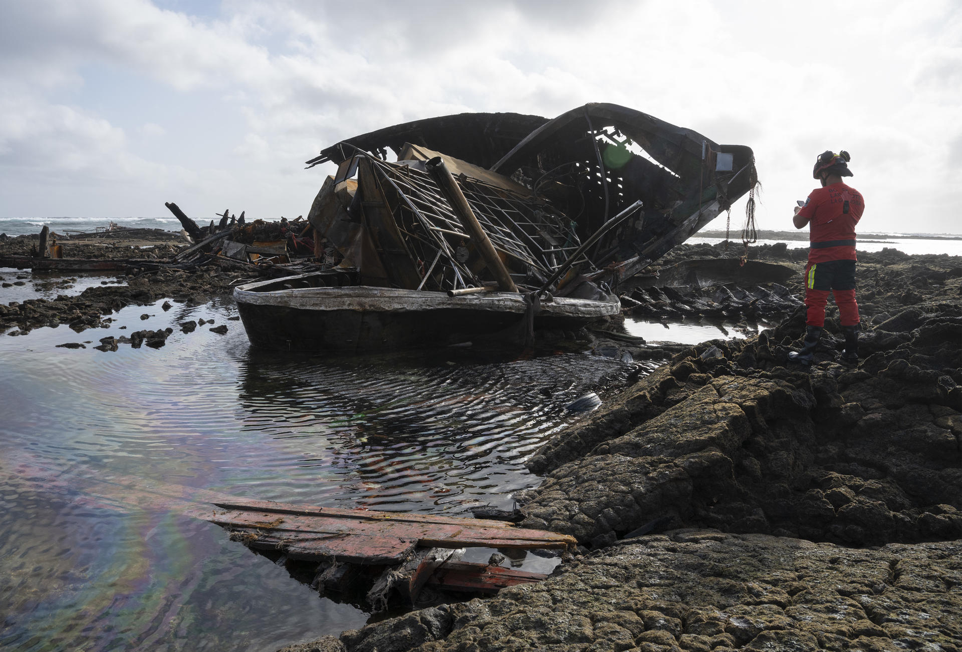 El Ministerio de Transportes ha decidido mantener al menos 24 horas más la emergencia por contaminación marítima decretada en Lanzarote tras encallar e incendiarse un pesquero marroquí en la costa de Órzola, pero solo por precaución, ya que el impacto del gasóleo derramado "es mínimo". En la imagen, tomada este jueves, restos del pesquero en la zona donde encalló, conocida como Charco de la Condesa, junto a la localidad de Órzola, en el norte de Lanzarote. EFE/Adriel Perdomo

