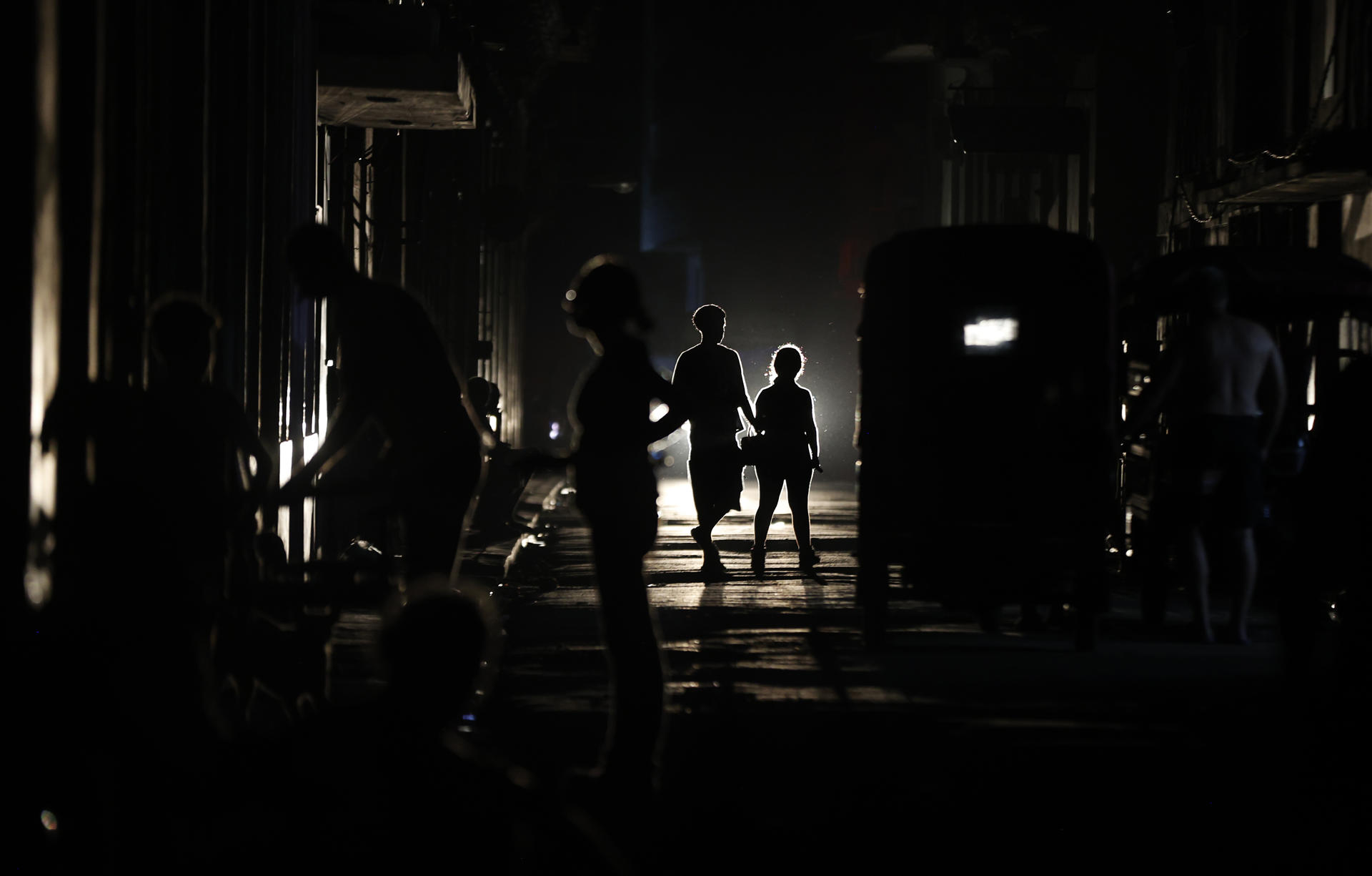 Personas caminan por una calle oscura este miércoles, en La Habana (Cuba). EFE/Ernesto Mastrascusa