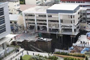 Bangkok (Thailand), 24/09/2025.- Thai officials inspect a large hole where a pickup truck is stuck after a road collapse in Bangkok, Thailand, 24 September 2025. A major street in Bangkok's Samsen district gave way, leaving a hole about 50 meters deep, 30 meters wide, and 30 meters long, but no injuries were reported. (Tailandia) EFE/EPA/RUNGROJ YONGRIT
