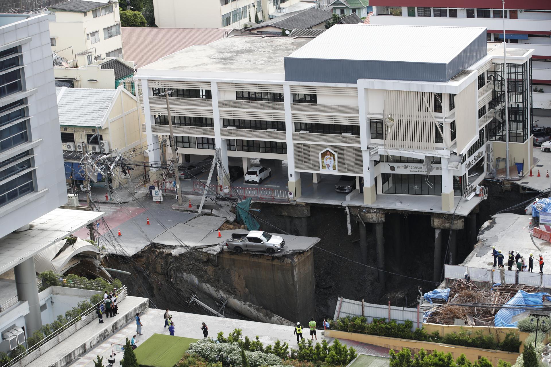 Bangkok (Thailand), 24/09/2025.- Thai officials inspect a large hole where a pickup truck is stuck after a road collapse in Bangkok, Thailand, 24 September 2025. A major street in Bangkok's Samsen district gave way, leaving a hole about 50 meters deep, 30 meters wide, and 30 meters long, but no injuries were reported. (Tailandia) EFE/EPA/RUNGROJ YONGRIT