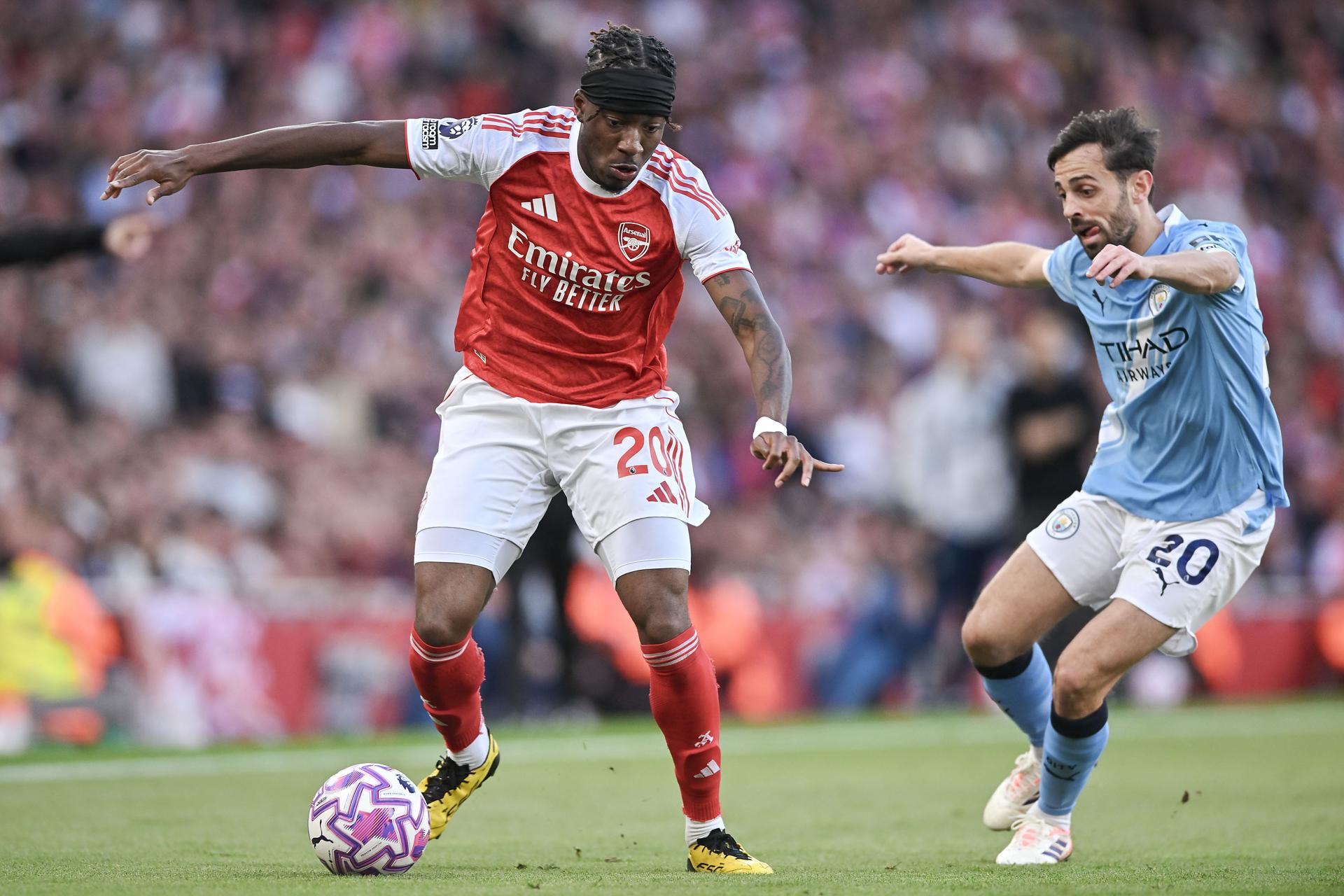 El jugador del Arsenal Noni Madueke (I)y Bernardo Silva, del Manchester City, en acción durante el partido de la Premier League que han jugado Arsenal FC y Manchester City, en Londres, Reino Unido. EFE/EPA/VINCE MIGNOTT