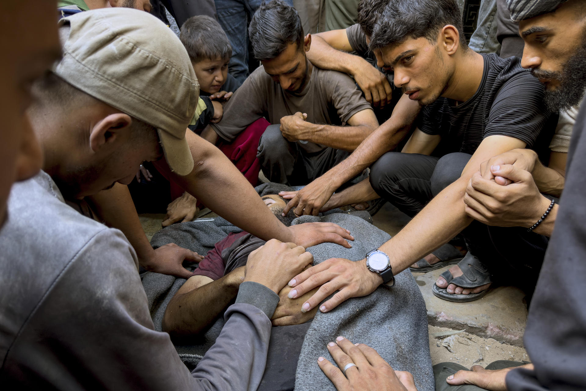 Varios hombres rodean a un joven que yace en el hospital de Al Shifa en Gaza. EFE/ Ahmad Awad
