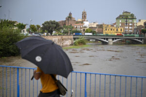 Una persona cruza este lunes un puente sobre el río Ana en Burriana (Castellón). EFE/Andreu Esteban