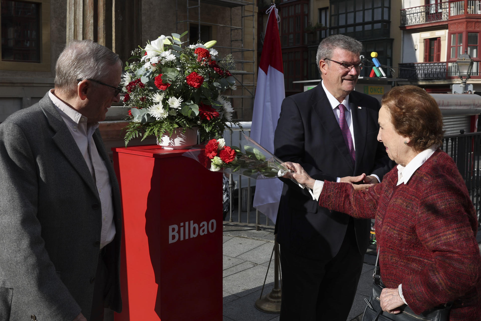 Un muer deposita un ramos de flores en presencia del alcalde de Bilbao, Juan Mari Aburto, (d) y un nieto del escritor donde este lunes se ha homenajeado al escritor, filósofo y pensador bilbaino Miguel de Unamuno en su Día Institucional. EFE/Luis Tejido
