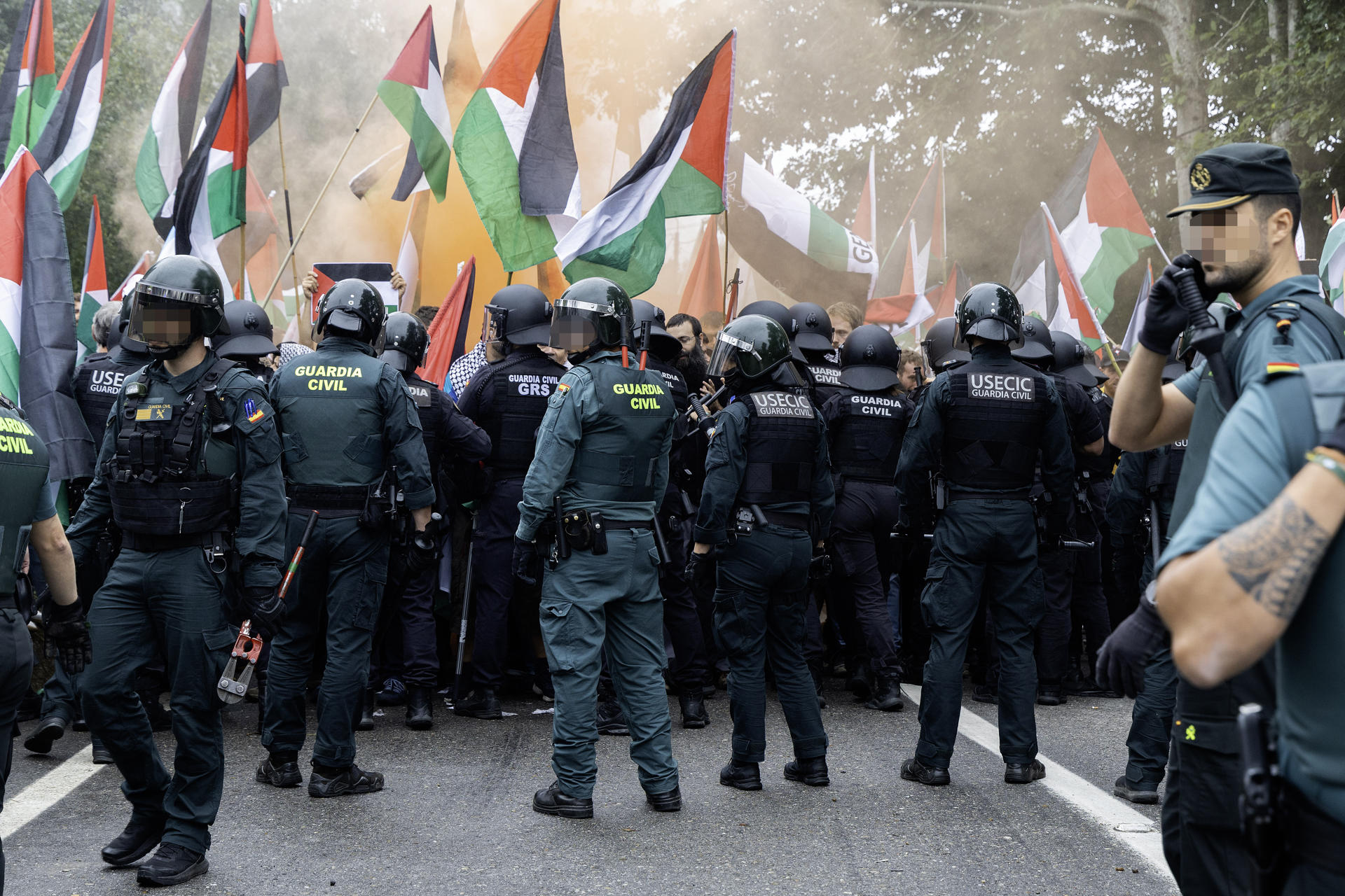 Agentes de la Guardia Civil y la Policía Nacional intervienen debido a la manifestación de numerosas personas que se concentran en el Alto de San Cosme para protestar por la presencia del equipo Israel-Premier Tech en la Vuelta a España, este martes durante la decimosexta etapa de la Vuelta a España entre las localidades pontevedresas de Poio y Mos. Las cargas policiales y la decisión de la organización de neutralizar la carrera a 8 kilómetros de la línea de meta marcaron esta etapa. EFE/ Salvador Sas