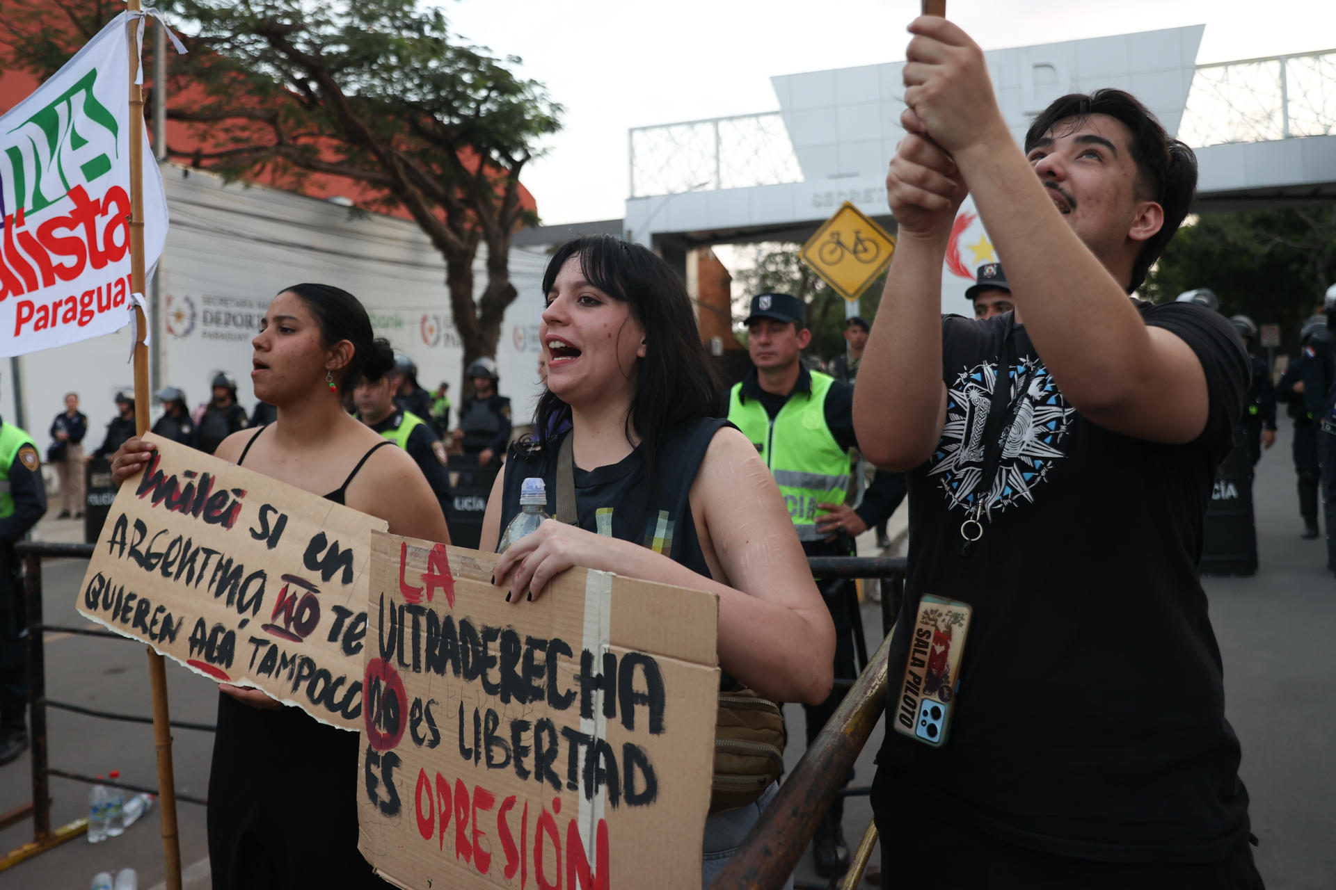 Personas sostienen carteles durante una manifestación contra la participación del presidente de Argentina, Javier Milei, en el Foro de Emprendedores Industriales de Paraguay FEIP 2025 este martes, frente a la Secretaría Nacional de Deportes, en Asunción (Paraguay). EFE/ Juan Pablo Pino