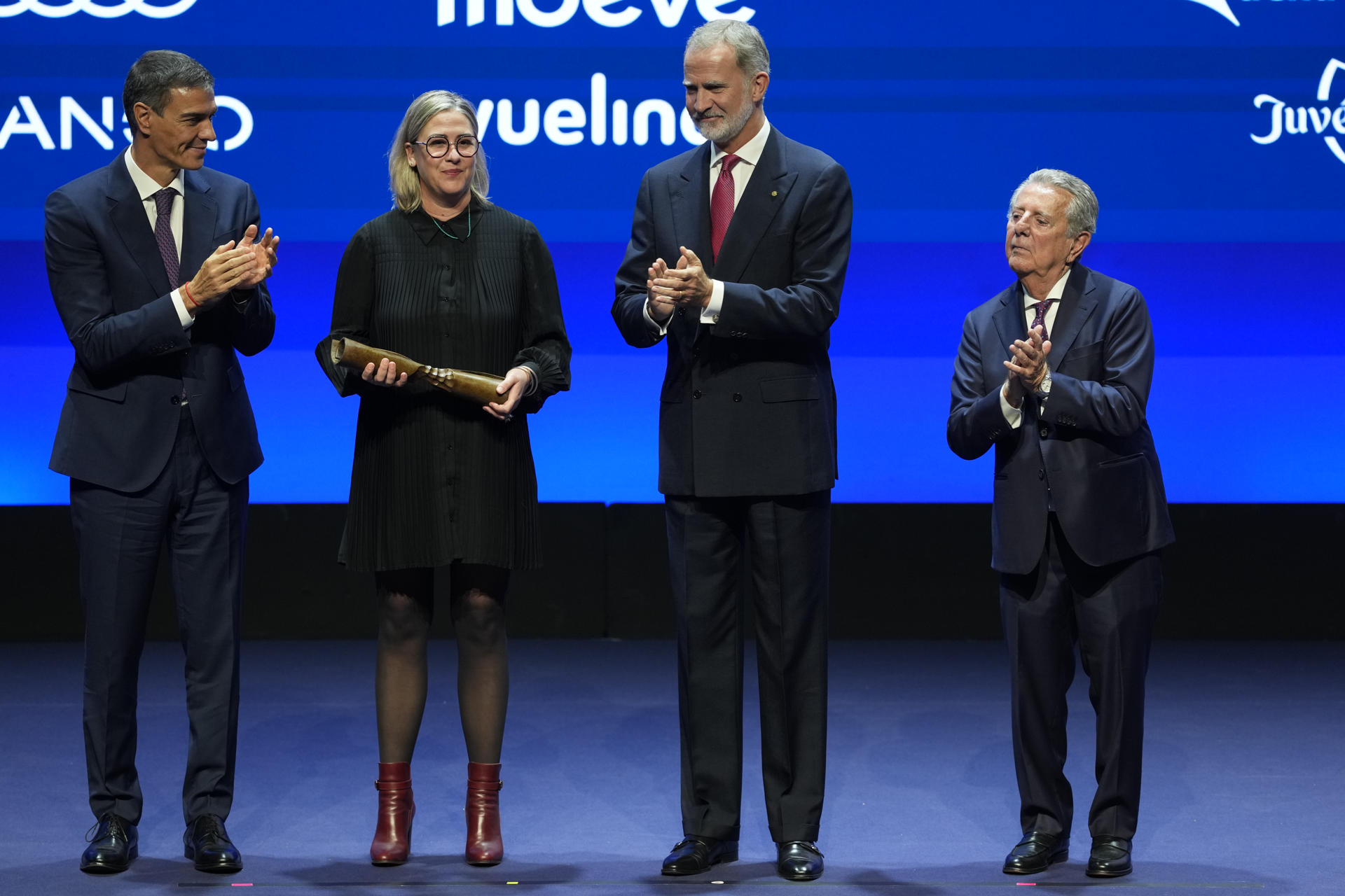 La francesa Caroline Darian (2i), hija de Dominique y Gisèle Pelicot, que denunció a su padre por violación, recibe el Premio Internacional, acompañada por el rey Felipe VI (2d), el presidente del Gobierno Pedro Sánchez (i) y el presidente-editor del diario La Vanguardia Javier Godó (d), durante la gala de los Premios Vanguardia que se celebran este lunes en el Palau de Congressos de Catalunya, en Barcelona. EFE/Alejandro García
