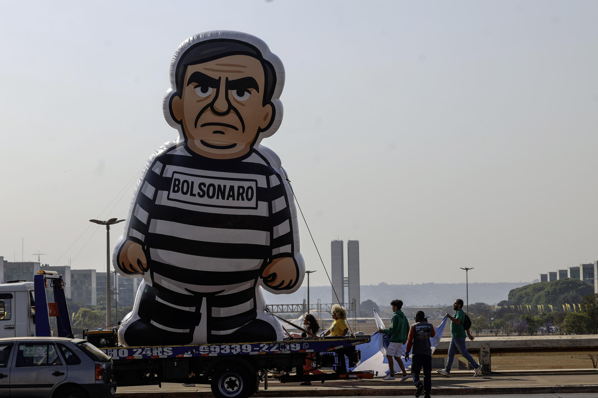 Personas caminan junto a un muñeco alusivo al expresidente de Brasil Jair Bolsonaro durante un desfile este 12 de septiembre de 2025, en Brasilia (Brasil). EFE/ Antonio Lacerda
