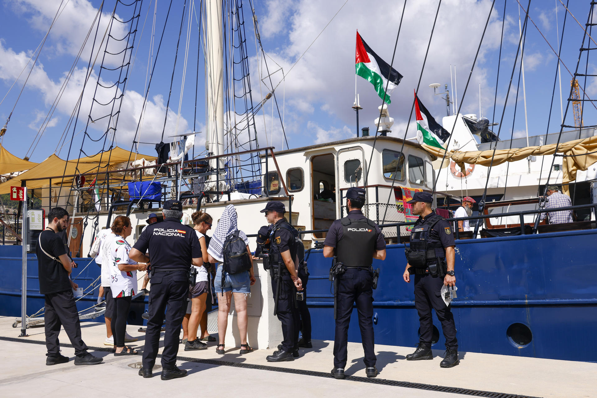 La veintena de barcos de la Global Sumud Flotilla o flotilla de la libertad que zarparon ayer domingo del Puerto de Barcelona hacia Gaza con ayuda humanitaria han regresado esta madrugada por el mal tiempo y sus capitanes se encuentran reunidos este lunes para decidir cuándo volver a partir. En la imagen, ageentes del CNP realizan un control ante uno de los barcos amarrado en el muelle de la Marina del Puerto de Barcelona.EFE/ Quique García