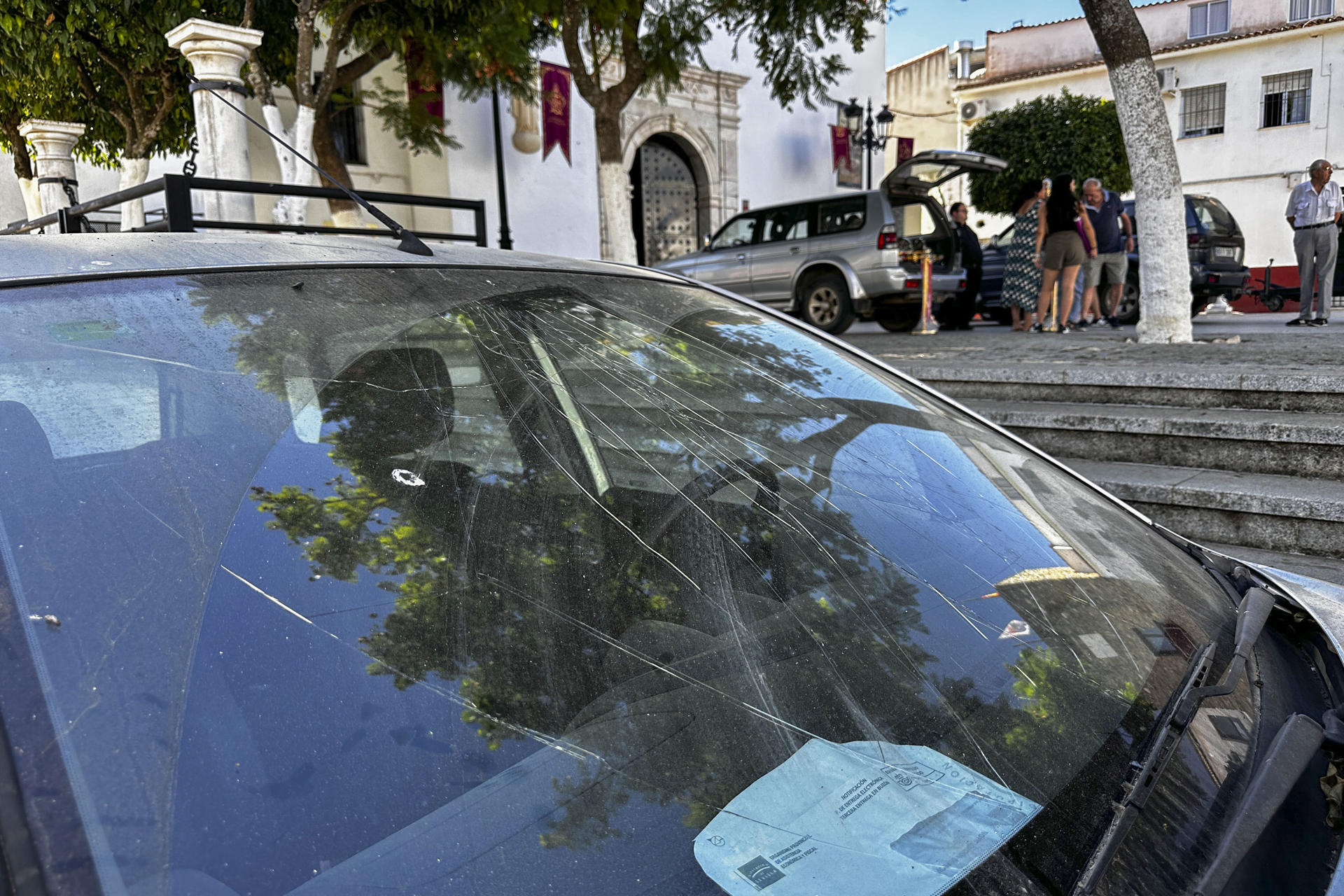 Desperfectos en uno de los vehículos en el lugar donde anoche al menos tres personas han resultado heridas, una de ellas grave, tras explotar un cohete en la localidad sevillana de Almadén de la Plata. EFE/David Arjona