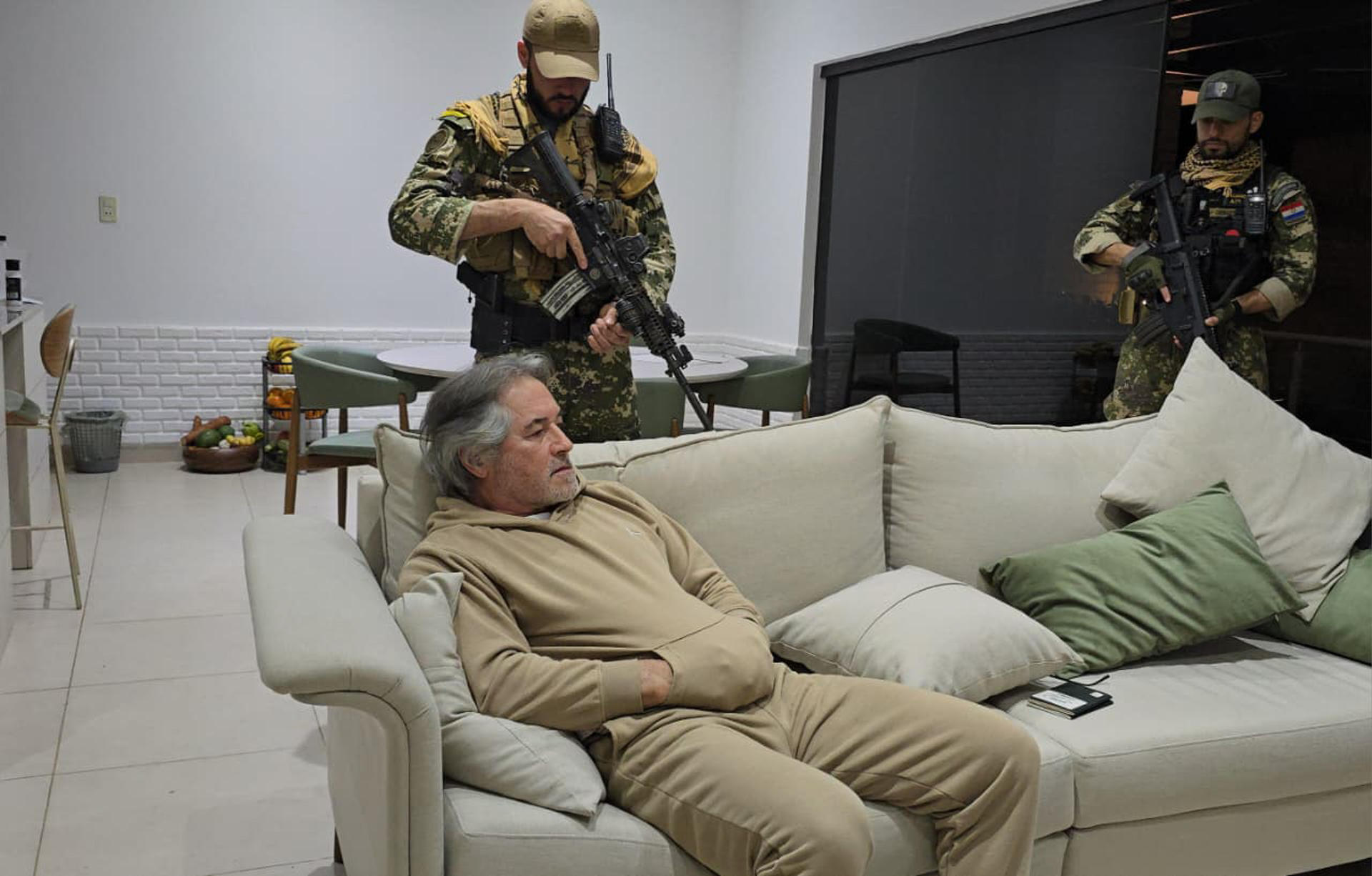 Fotografía cedida que muestra a integrantes de las Fuerzas Armadas custodiando al presunto líder del grupo criminal La Barredora, Hernán Bermúdez Requena, este 13 de septiembre de 2025 en Mariano Roque Alonso (Paraguay). EFE/ Secretaría Nacional Antidrogas de Paraguay