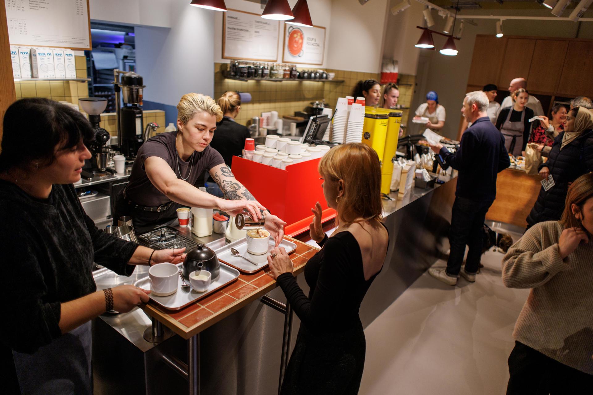 Baristas sirven cafés en un establecimiento londinense. EFE/EPA/TOLGA AKMEN
