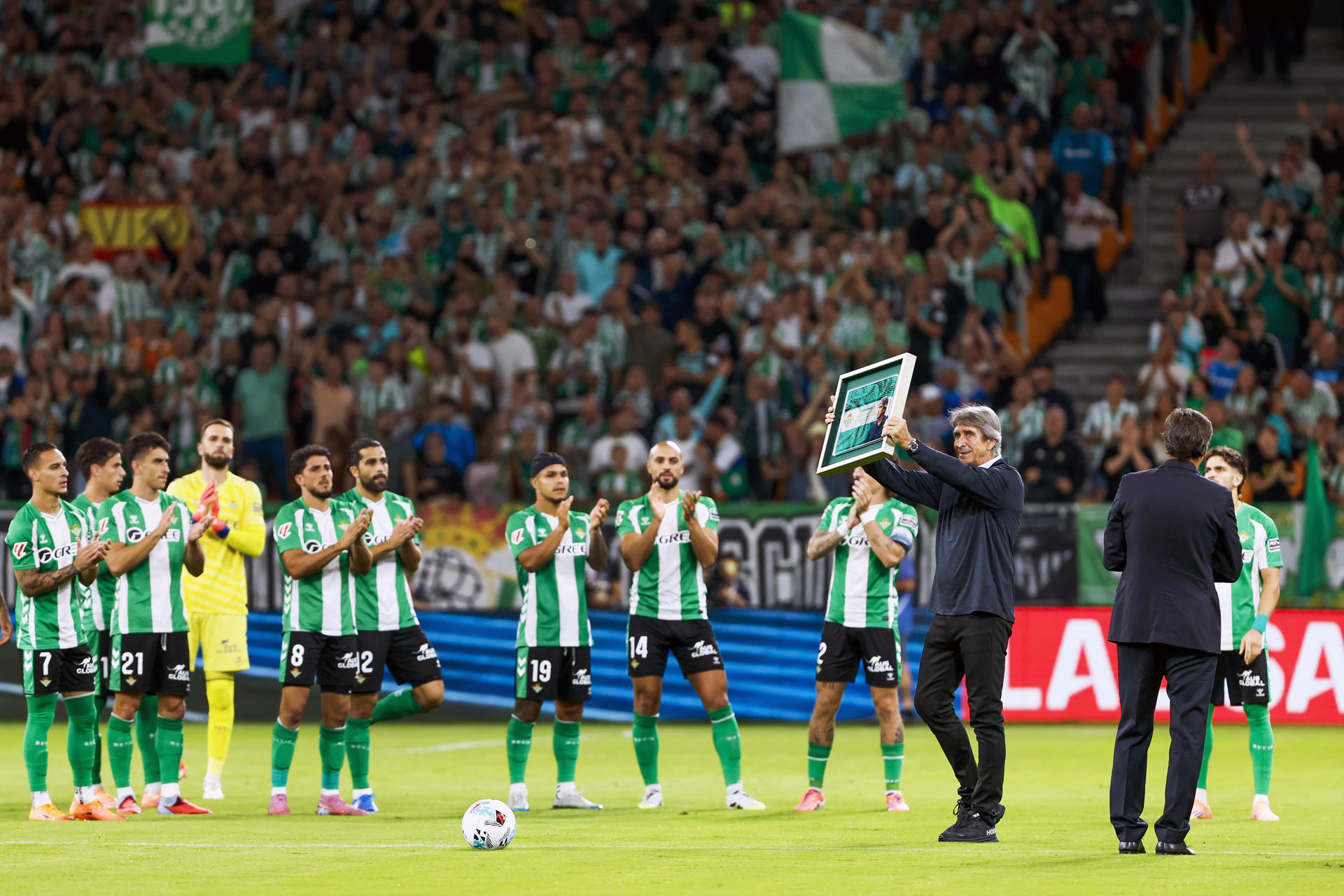 El entrenador del Real Betis Manuel Pellegrini recibe un reconocimiento por ser el técnico con más partidos en la historia del club, antes del partido de Laliga el conjunto verdiblanco disputó ante el Osasuna en el estadio de La Cartuja. EFE / Julio Muñoz