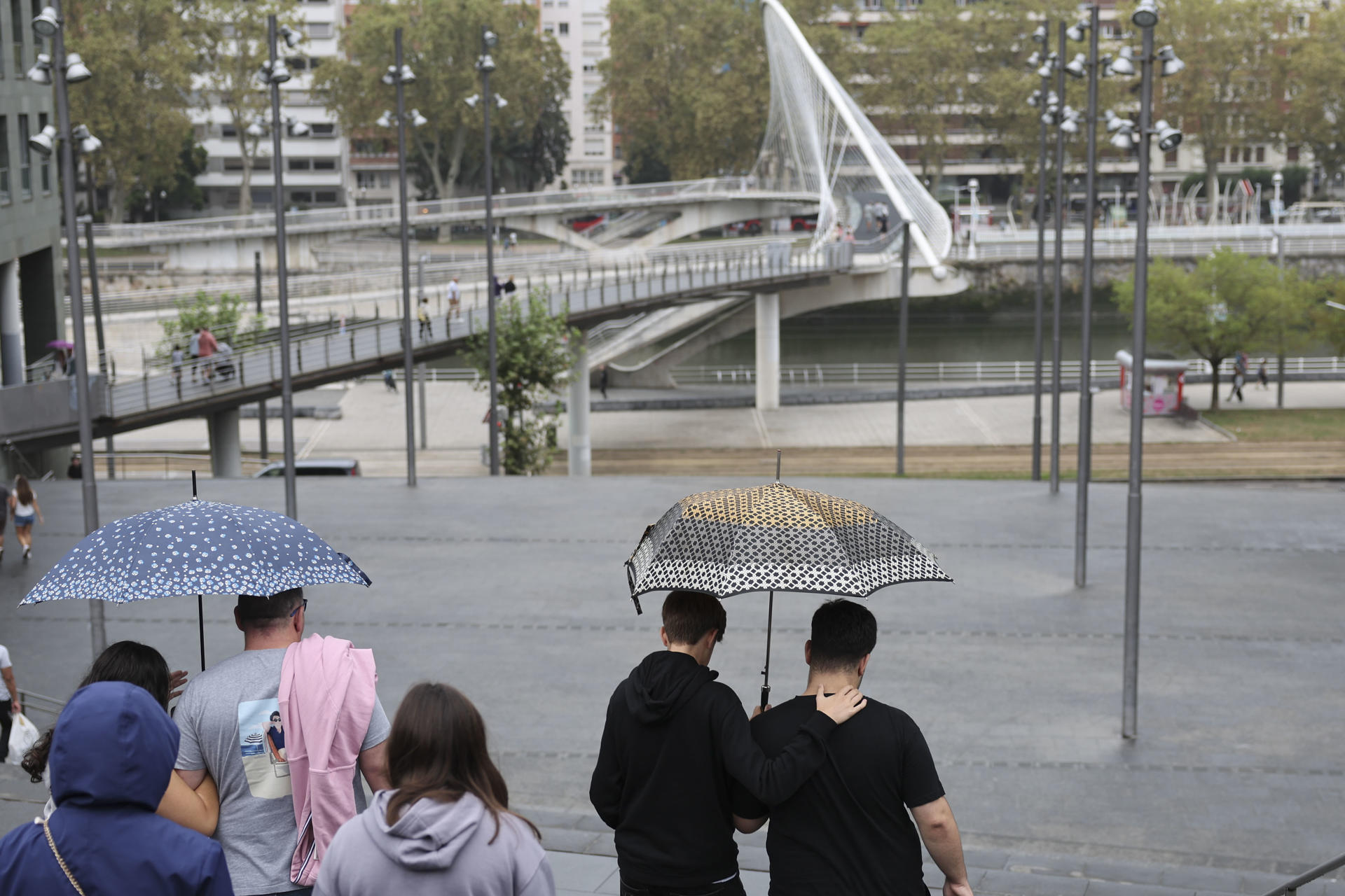 Personas se protegen con paraguas de la lluvia en Bilbao, en una imagen de archivo. EFE/Luis Tejido