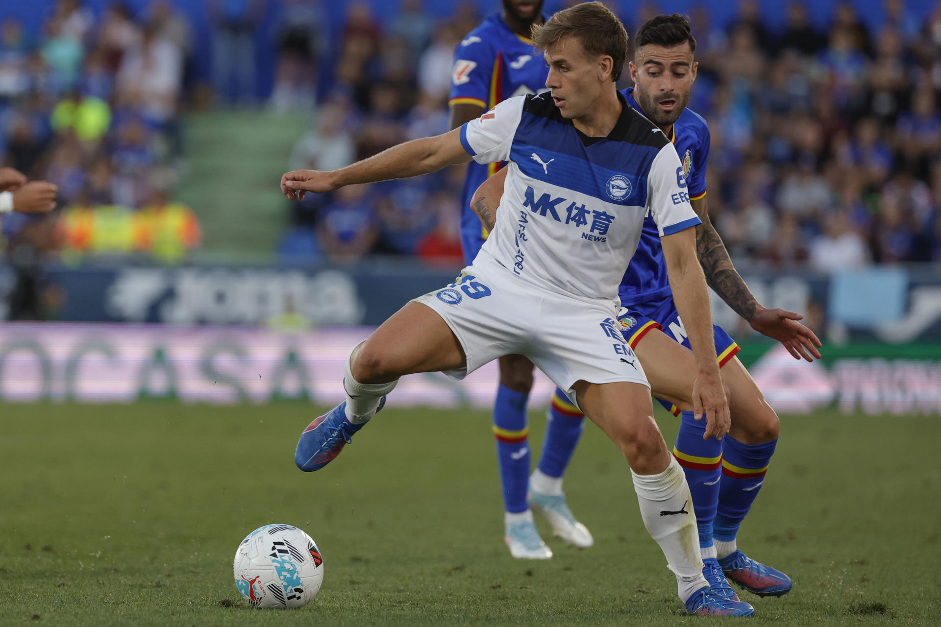 El delantero del Alavés Pablo Ibáñez (i) controla la pelota ante Diego Rico (d), del Getafe, durante el partido de la jornada 6 de la Liga disputado en el estadio Coliseum de Getafe. EFE/Zipi Aragón
