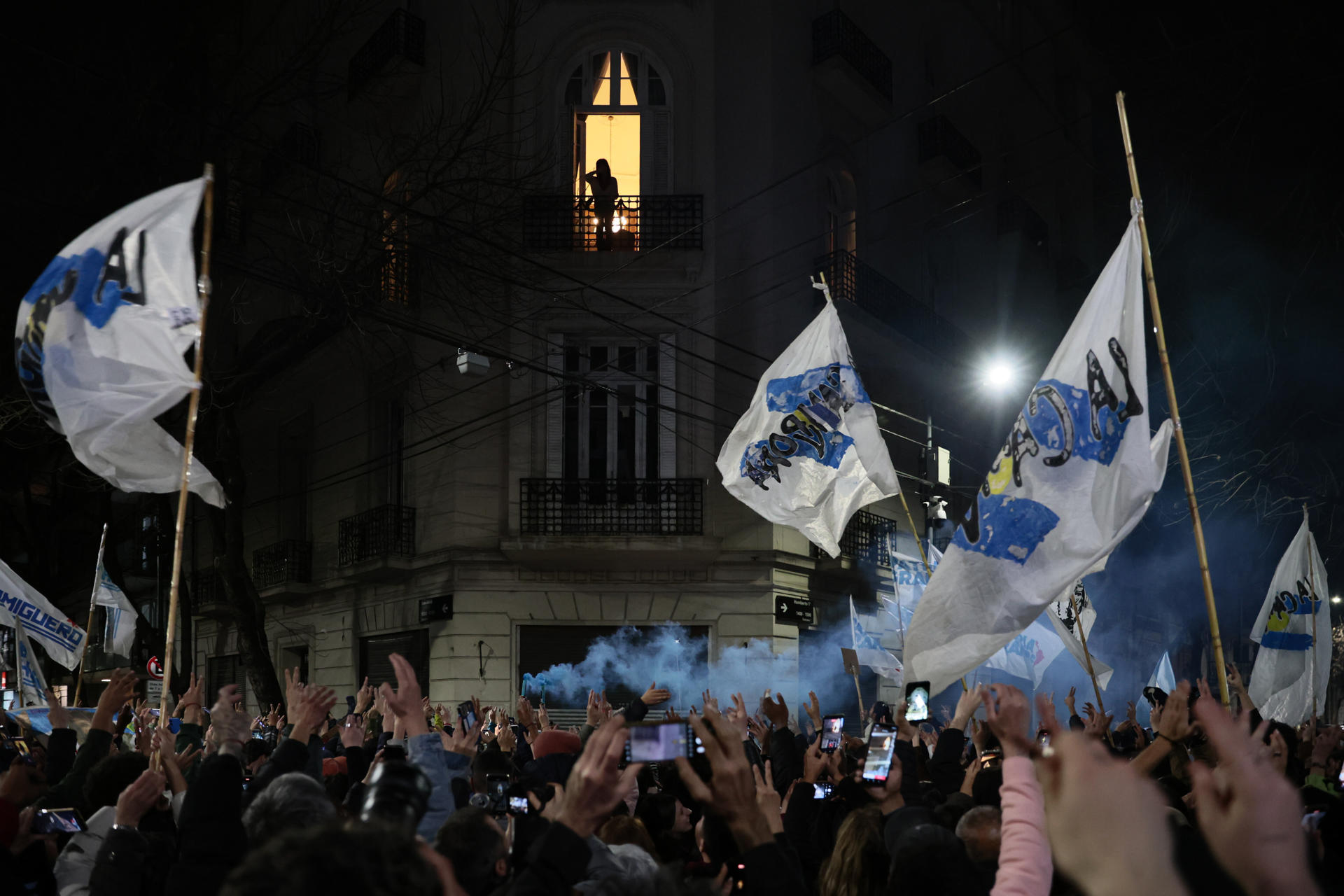 Personas celebran tras conocer los resultados de las elecciones legislativas de la provincia de Buenos Aires frente a la casa de la expresidenta Cristina Fernández, este domingo, en Buenos Aires (Argentina). Fernández salió a su balcón para saludar a los cientos de seguidores que se congregaron a las puertas de su casa, donde cumple prisión domiciliaria, para celebrar el gran triunfo peronista en las elecciones provinciales de Buenos Aires. EFE/ Adan González