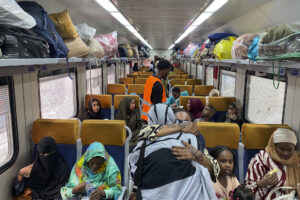 Dos mujeres se despiden con un abrazo en uno de los vagones del tren reservado para que los refugiados sudaneses retornen a su país desde El Cairo. En la céntrica estación de ferrocarril de Ramsés, en El Cairo, el bullicio habitual se mezcla con aires de despedida y esperanza. Alrededor de 940 refugiados sudaneses, cargados con grandes bultos y maletas con pertenencias y recuerdos acumulados durante su exilio, se preparan para abordar el tren que les llevará de regreso a su país. EFE/Rosa Soto