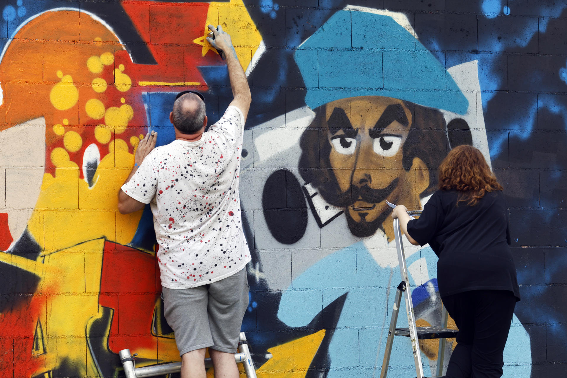 Al cierre del Verano, el certamen de Arte urbano de las Meninas de Canido regresa a sus orígenes vinculados con el grafiti y la reivindicación social, para reunir a miles de personas durante el fin de semana en el barrio alto de la ciudad de Ferrol. EFE/Kiko Delgado