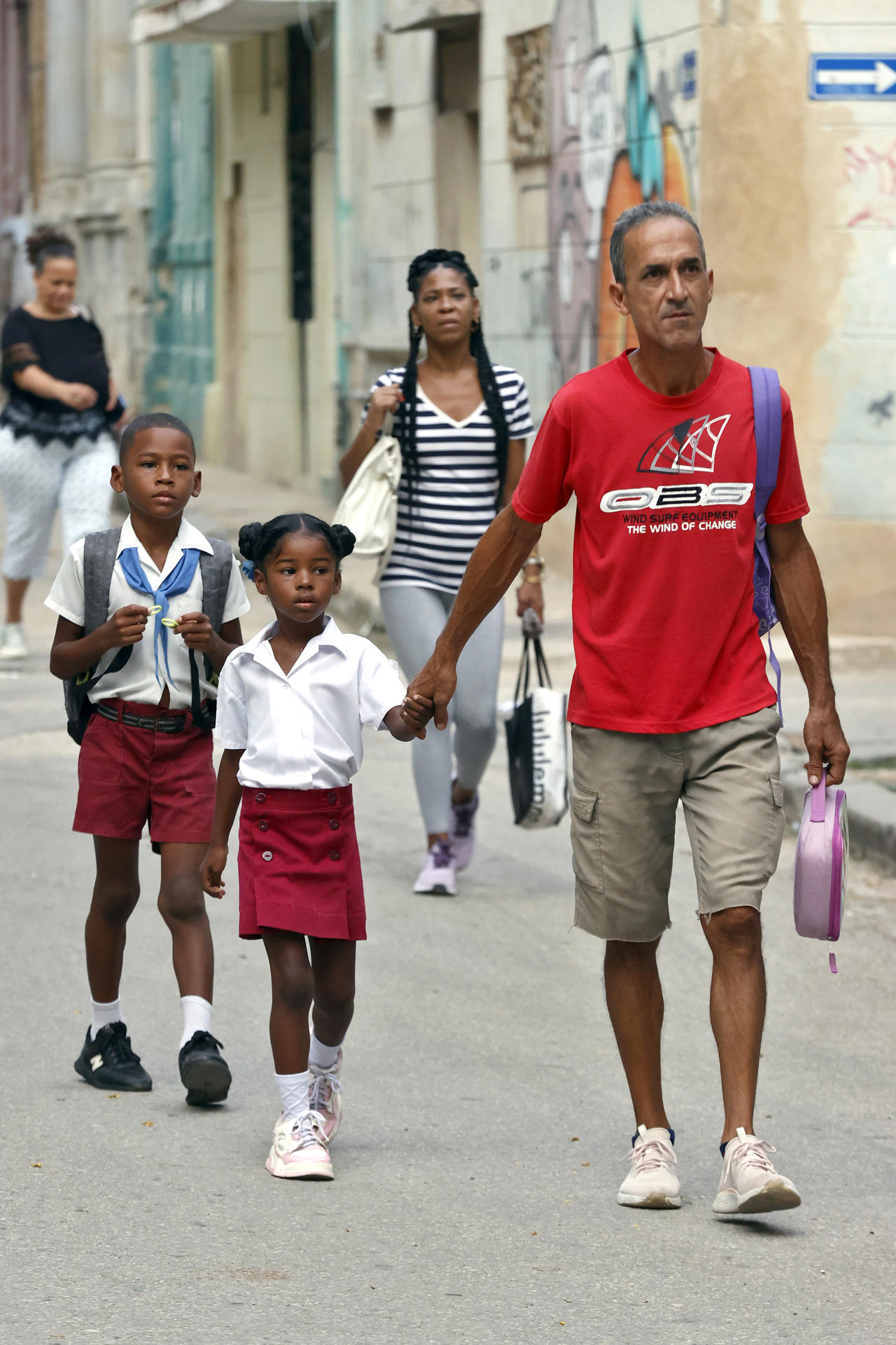 Estudiantes caminan junto a sus padres este lunes, en La Habana (Cuba). EFE/ Ernesto Mastrascusa