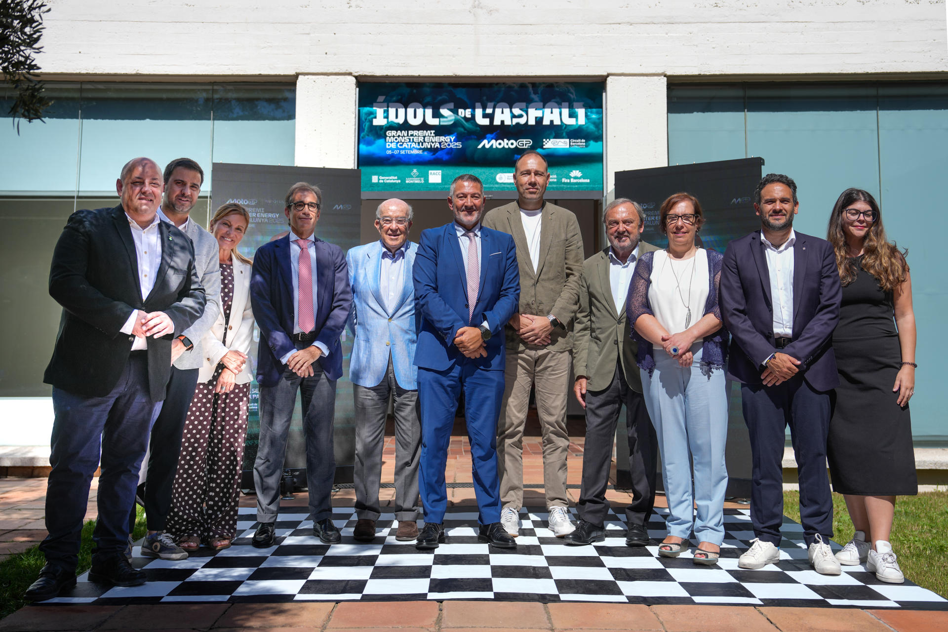 El consejero delegado de Dorna Sports, Carmelo Ezpeleta(5i), y conseller de Empresa y Trabajo de la Generalitat de Cataluña, Miquel Sàmper (c) junto a otras autoridades posan durante la presentación de las últimas novedades del GP Monster Energy de Cataluña 2025, que se disputará en el  el circuito de Barcelona-Cataluña, en Montmeló (Barcelona). EFE/ Enric Fontcuberta