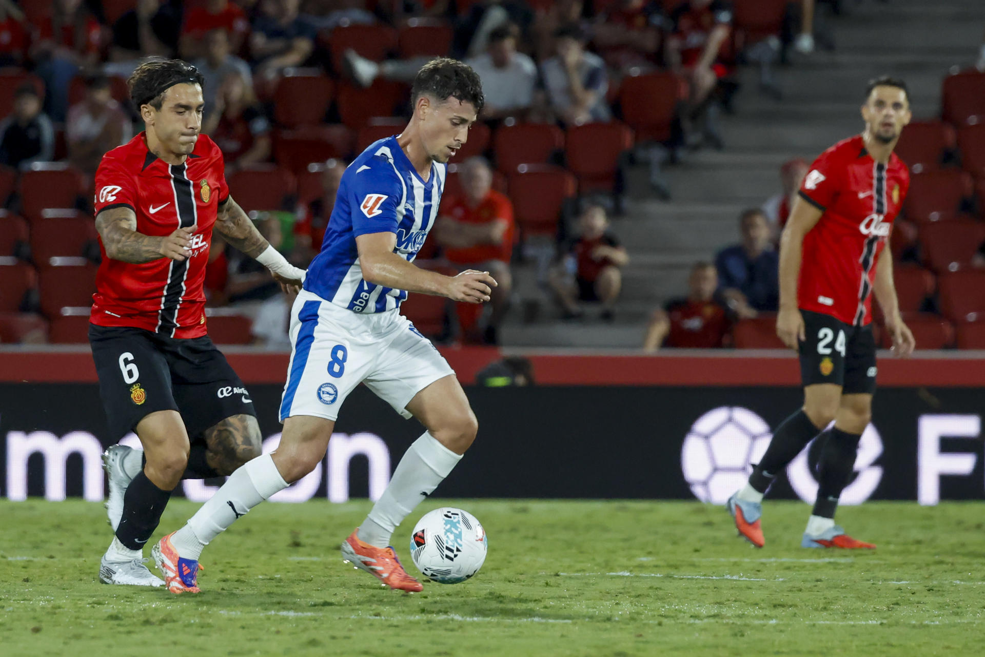 El centrocampista del Alavés, Antonio Blanco (d), conduce el balón ante el centrocampista del Mallorca, Antonio Sánchez, durante el encuentro correspondiente a la jornada 7 de Laliga EA Sports que disputaron Mallorca y Alavés en el estadio de Son Moix, en la capital balear. EFE/CATI CLADERA.