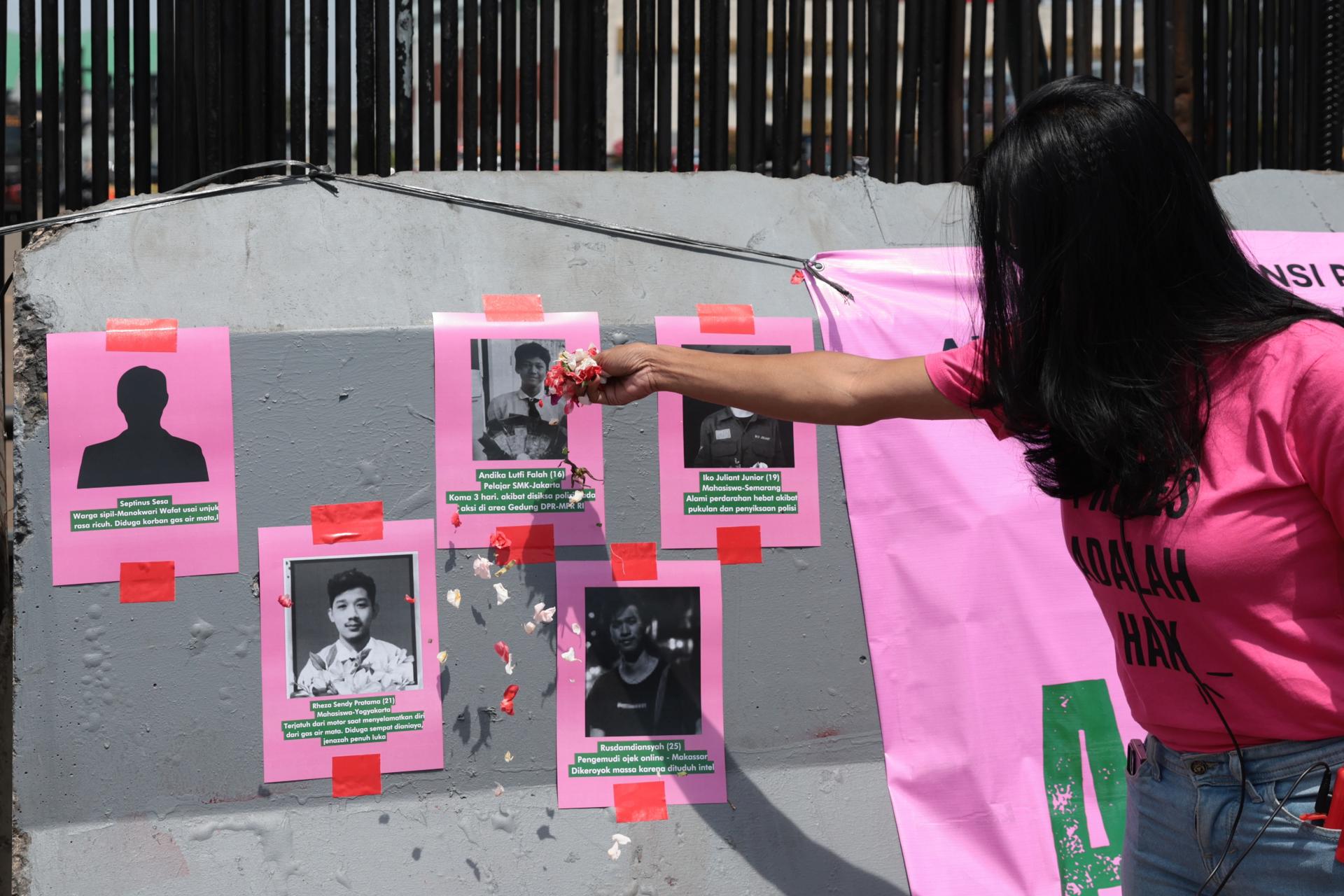 JAKARTA (Indonesia), 03/09/2025.- An activist from Indonesia Women’s Alliance scatter flowers to photos of death of violence victims in front of Parliament building in Jakarta, Indonesia, 03 September 2025. Hundreds women activists staged an anti-violence rally due protests across the country following the death of a motorbike hailing driver during an earlier protest against the housing allowance for members of parliament on the night of 28 August in Jakarta. (Protestas) EFE/EPA/ADI WEDA