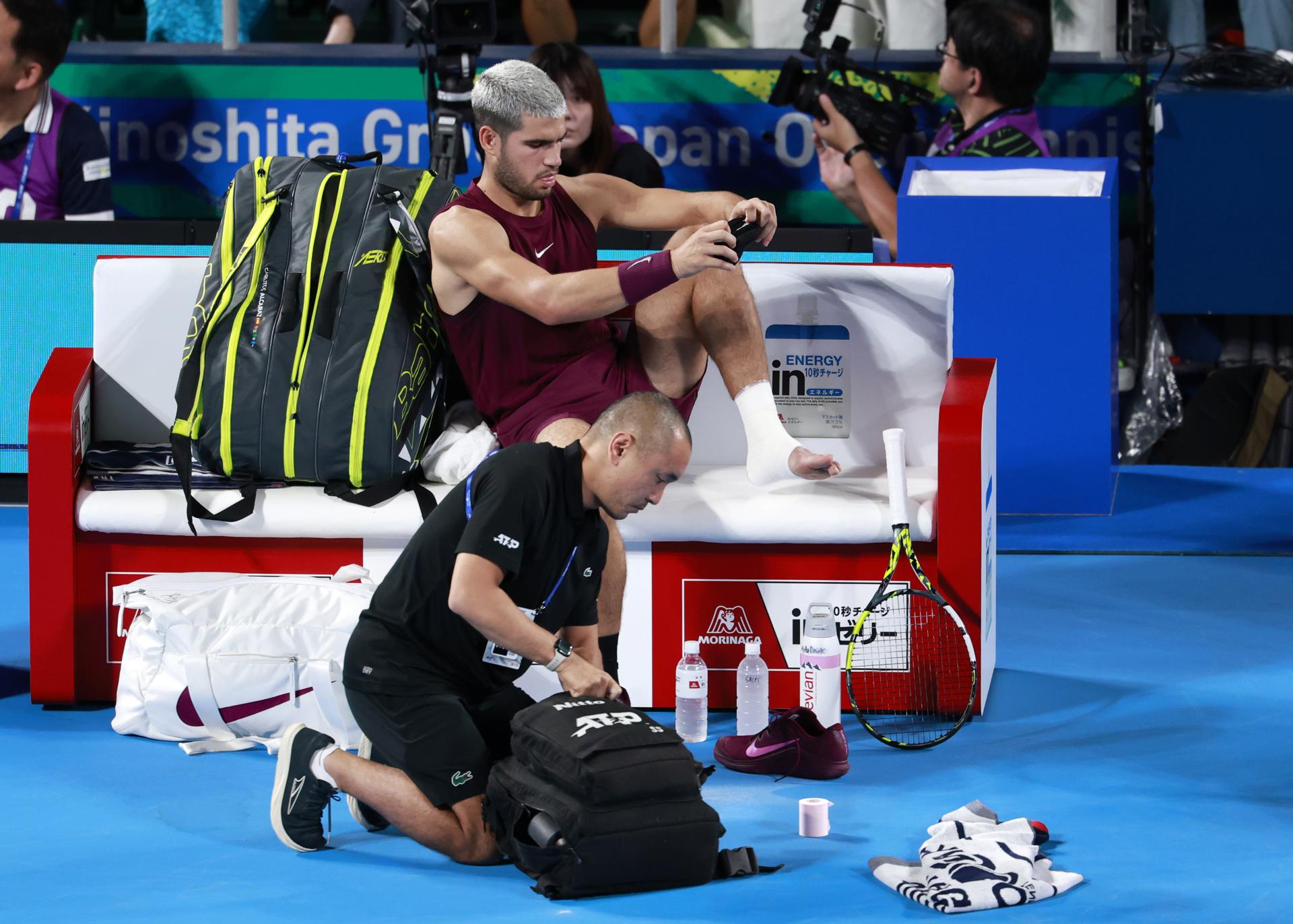 El tenista español Carlos Alcaraz es atendido por una lesión sufrida durante el partido contra el argentino Sebastián Báez en el torneo de Tokio disputado este jueves. EFE/ FRANCK ROBICHON
