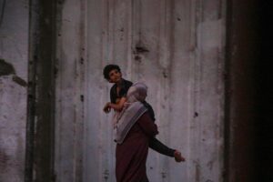 Una madre palestina huye de ciudad de Gaza cargando a su hijo enfermo el 28 de septiembre de 2025. EFE/EPA/MOHAMMED SABER